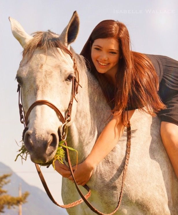 Alisha Newton as Georgie in Heartland, riding a horse through a sunlit field