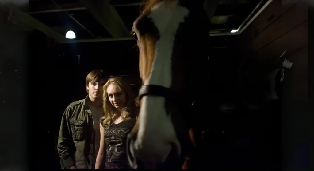 Amber Marshall on the set of Heartland, interacting with a horse.