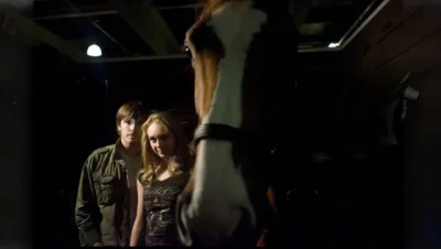 Amber Marshall on the set of Heartland, interacting with a horse.